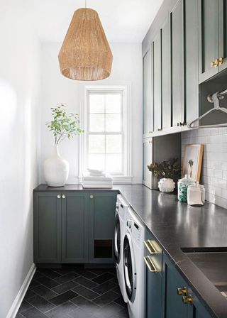L-shaped small laundry room ideas in a white scheme with dark gray-blue painted cabinets.