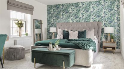 bedroom with green designed wall grey bed with designed cushion white window and wooden table