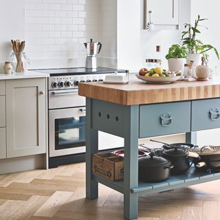 Painted butcher's block style island with saucepan on its shelf in a kitchen