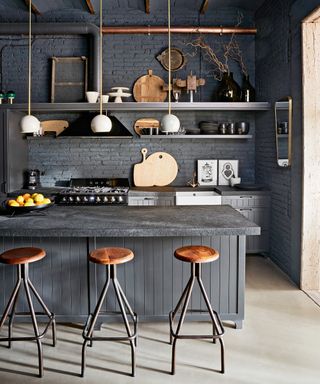 An example of peninsula kitchen layout ideas in a dark gray scheme with rustic wood accents.