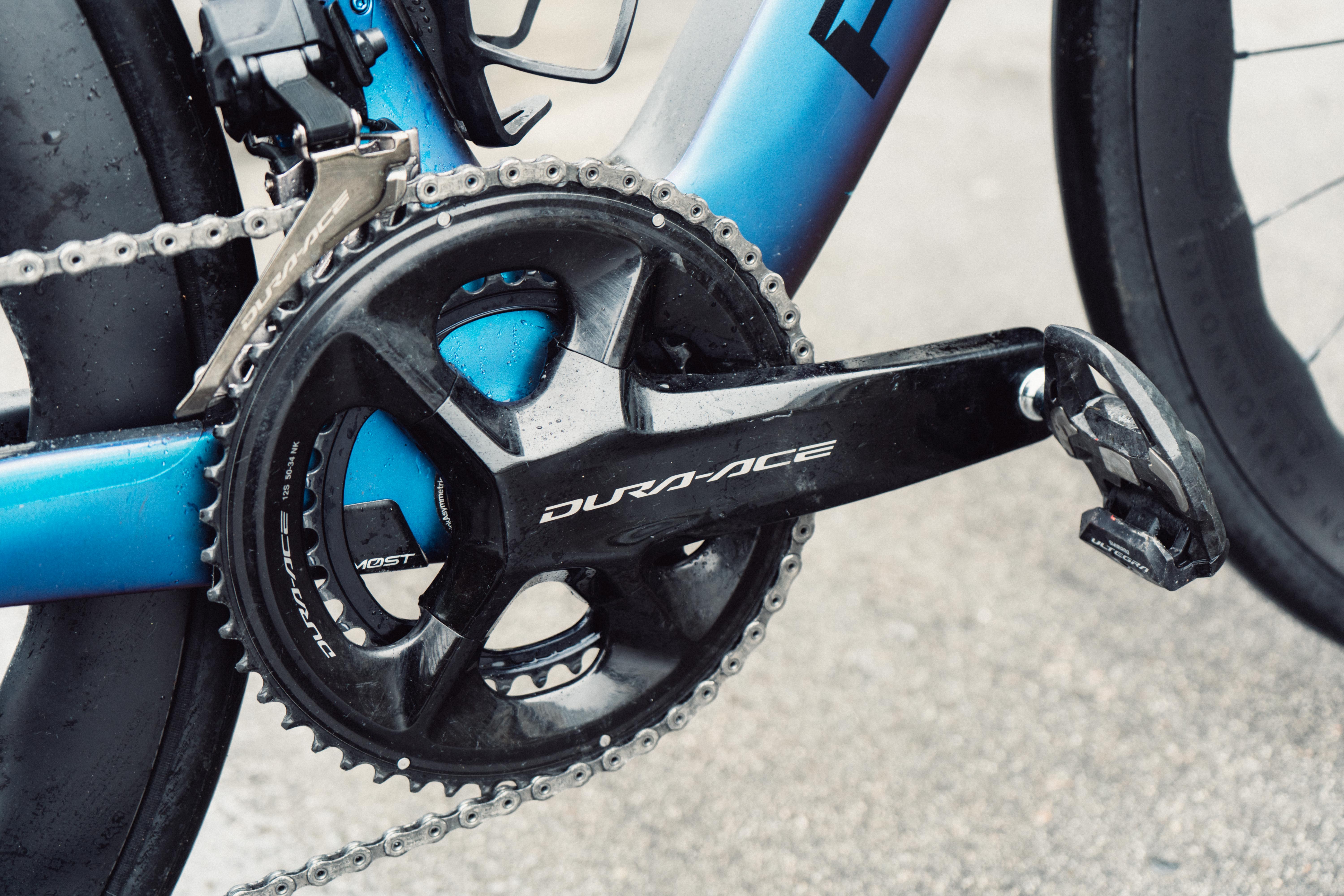 A black crankset on a blue racing bike