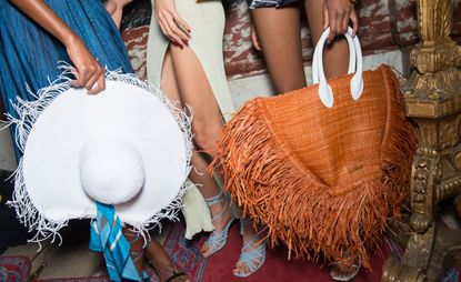 Models wear white straw hat with blue skirt, light green dress and brown fringed bag