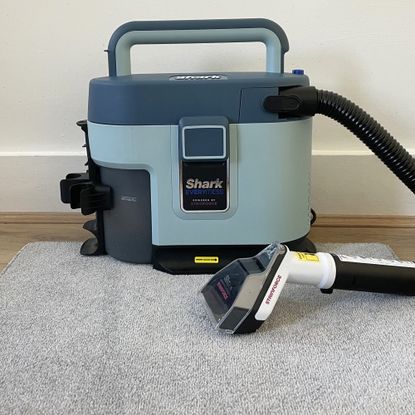 Shark EveryMess sitting on a grey carpet sample