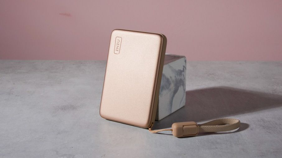 The Iniu SnapGo Air 10000mAh Power Bank leaning against a marble block.