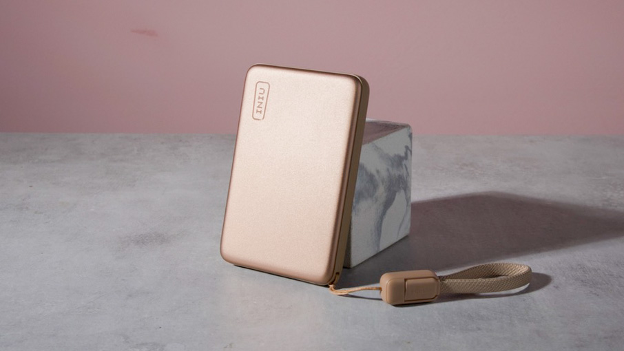 The Iniu SnapGo Air 10000mAh Power Bank leaning against a marble block.