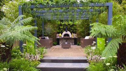 decking with pergola covered in climbing plants