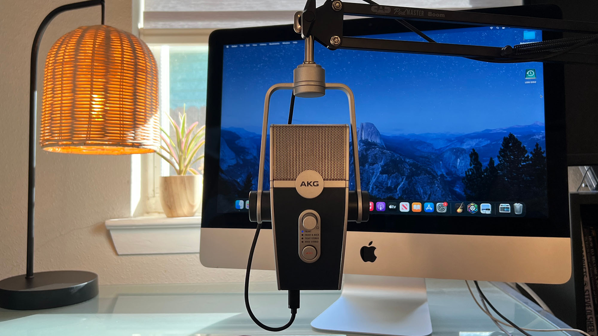 An AKG Lyra on a desk in front of an iMac