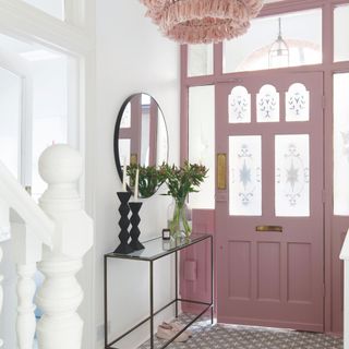 Pink front door interior, with decorated glass panels bringing light into the hallway