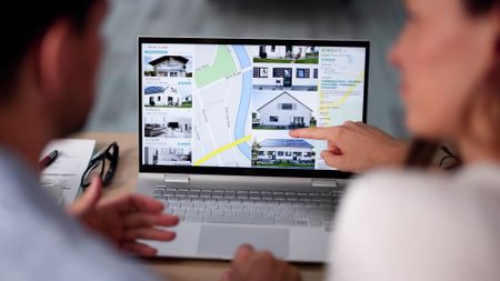 A couple comparing homes on a real estate website