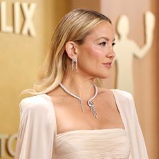 Kate Hudson at the 2026 actor awards wearing a cape gown with diamond jewelry