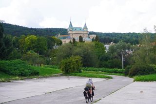 Image shows Anna cycling towards Castle of Spirits (Bojnice Castle) in Slovakia