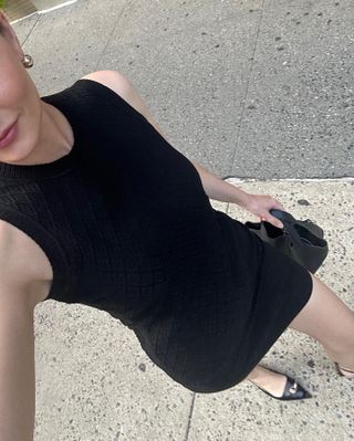 Woman wearing a black dress and Tory Burch pierced flats