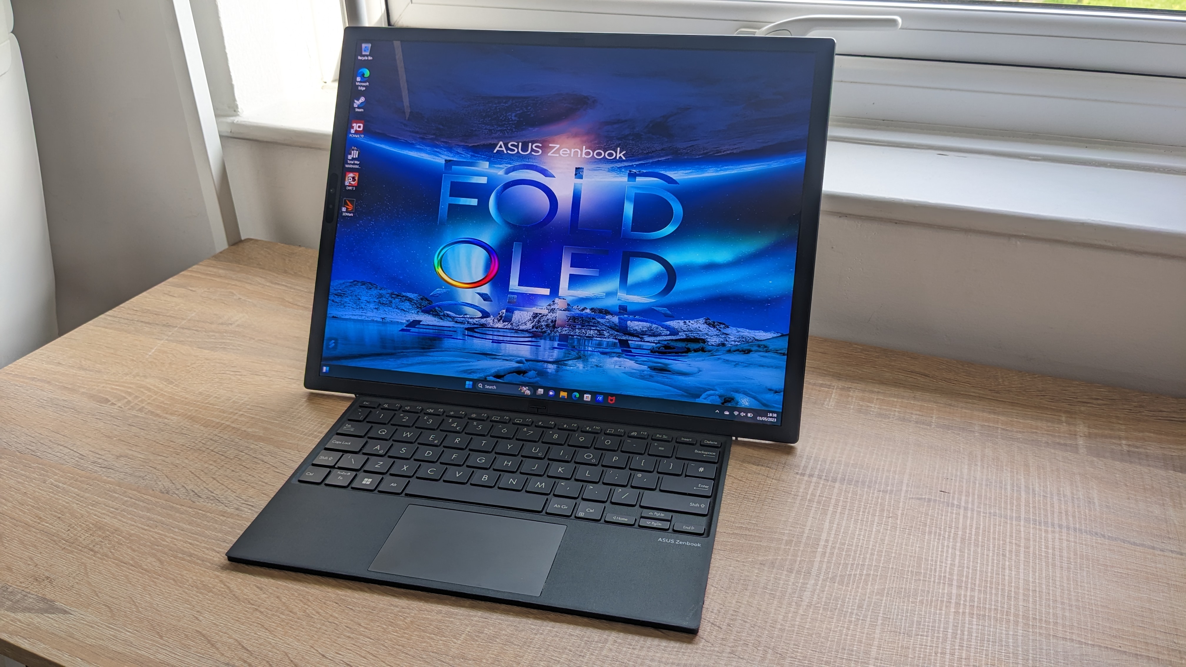 The Asus Zenbook 17 Fold OLED pictured on a wooden desk.