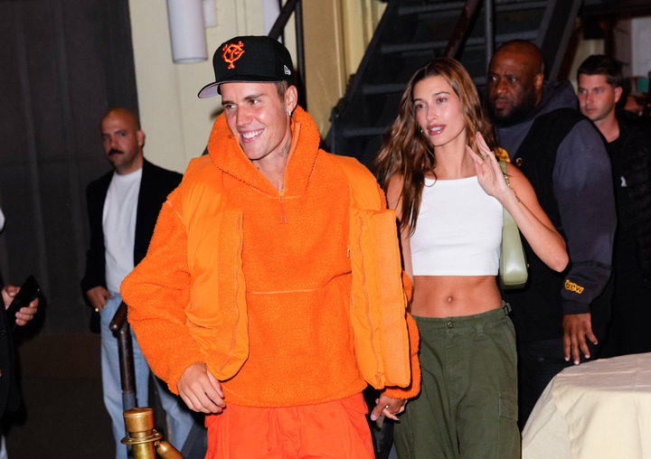 Image of Hailey and Justin Bieber, Hailey is wearing a white tank khaki trousers and a white vest top.
