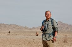Laureate Liu Shaochuang, laureate of 2023 Rolex Awards for Enterprise, standing amid desert with binoculars