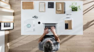 Designer sitting at desk and working on his laptop, with the best desk accessories