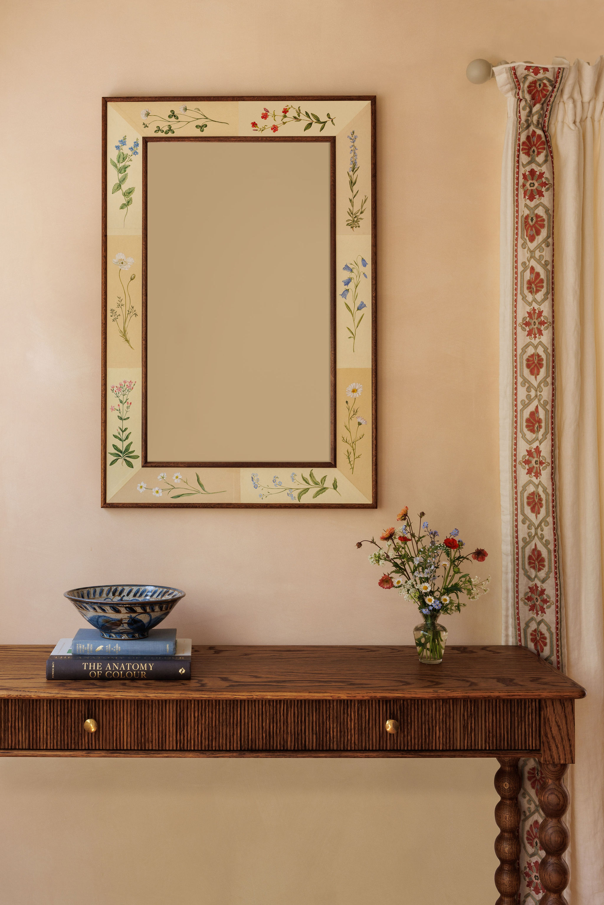A painted mirror hanging on a wall