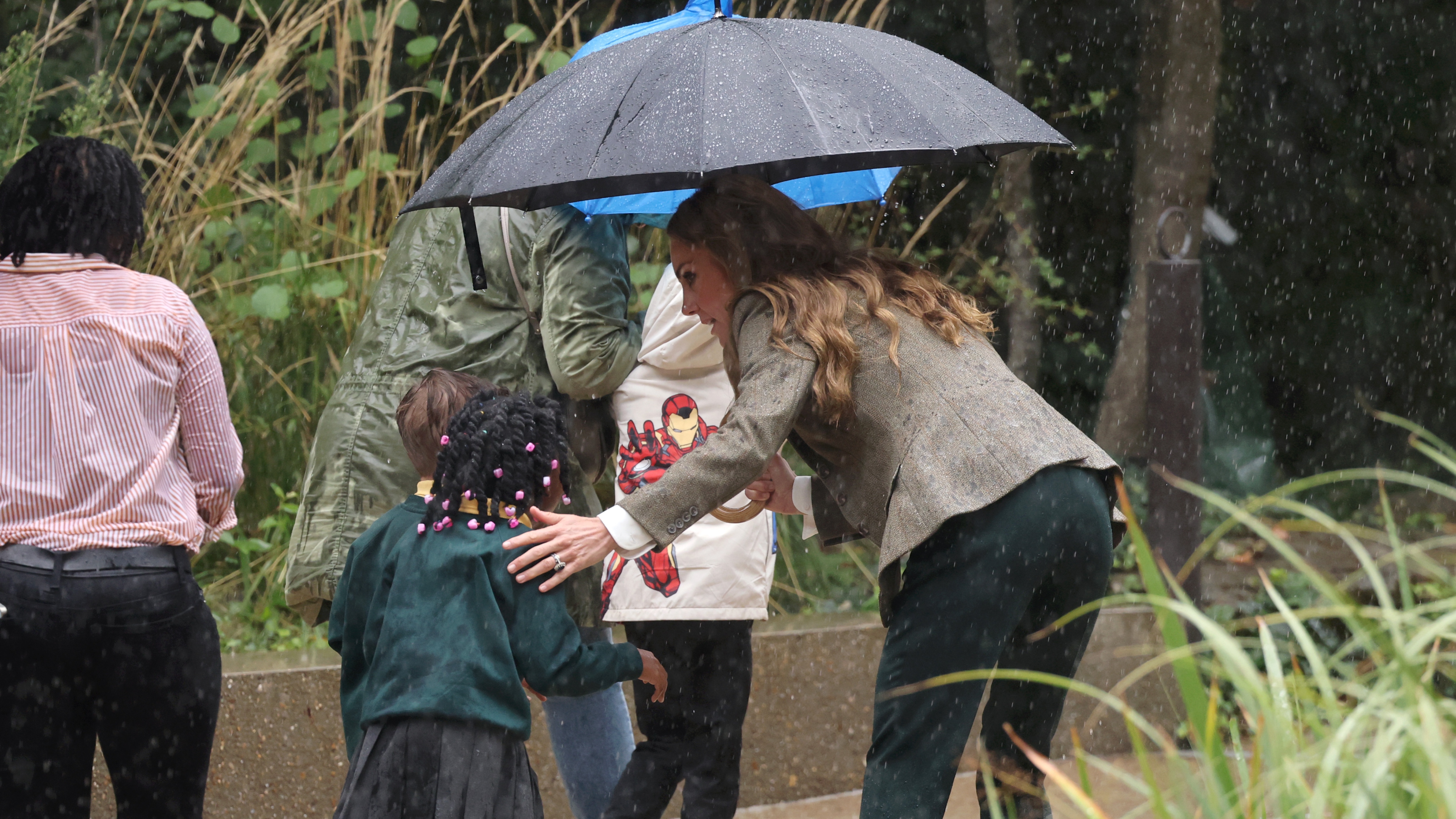 Catherine, Princess of Wales holds an umbrella and talks to a child during her visit to the Natural History Museum&#039;s newly renovated gardens on September 04, 2025