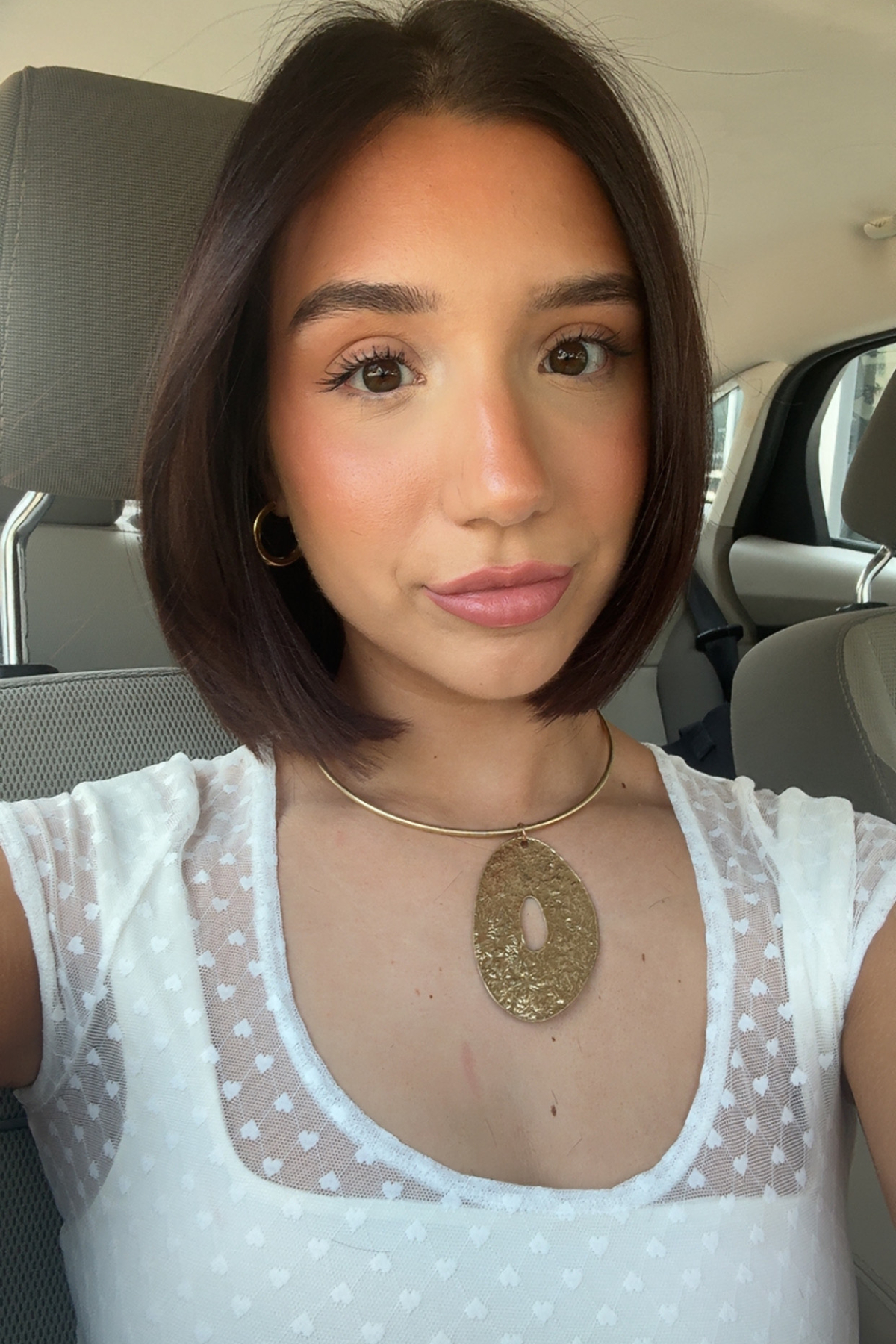 Alaina Gagliano after testing the Lancôme Teint Idole Ultra 24H Wear Matte Foundation with a white shirt and large necklace and brown hair.