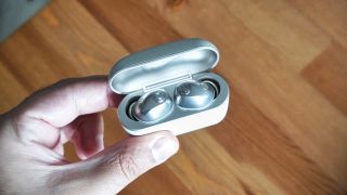 Sennheiser Momentum True Wireless 5 in white, showing details of the buds held in a hand