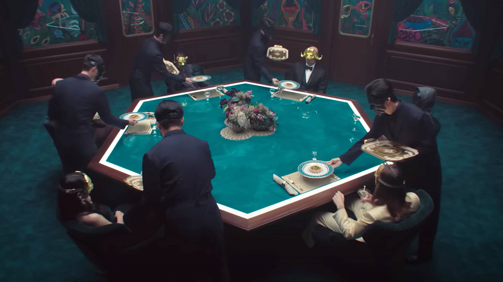 Screenshot taken of the VIPs sitting around a dining table in "Squid Game" season 3 final trailer
