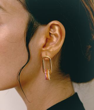 Woman wearing gold hoops by colourful jewellery brand Boulo