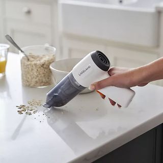 Using the Lakeland 3-in-1 Mini Vacuum Cleaner to vacuum crumbs on a kitchen counter