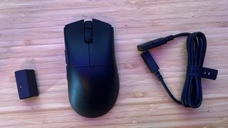 Razer DeathAdder V3 Hyperspeed with USB converter and cable on a wooden desk