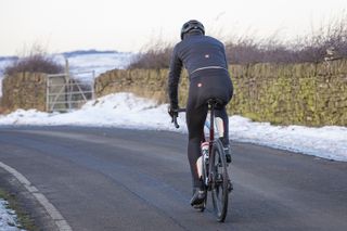 rider on a snowy lane photographed from behind