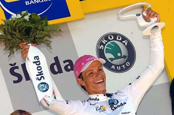 The new young rider classification leader smiles to the crowd.