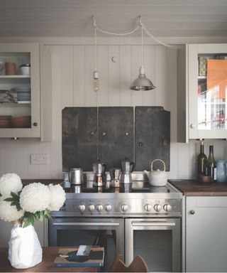 gray kitchen with panelled walls and a chrome cooker