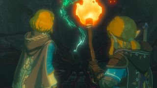 Link y Zelda con una antorcha en la mano entran en un pasadizo oscuro