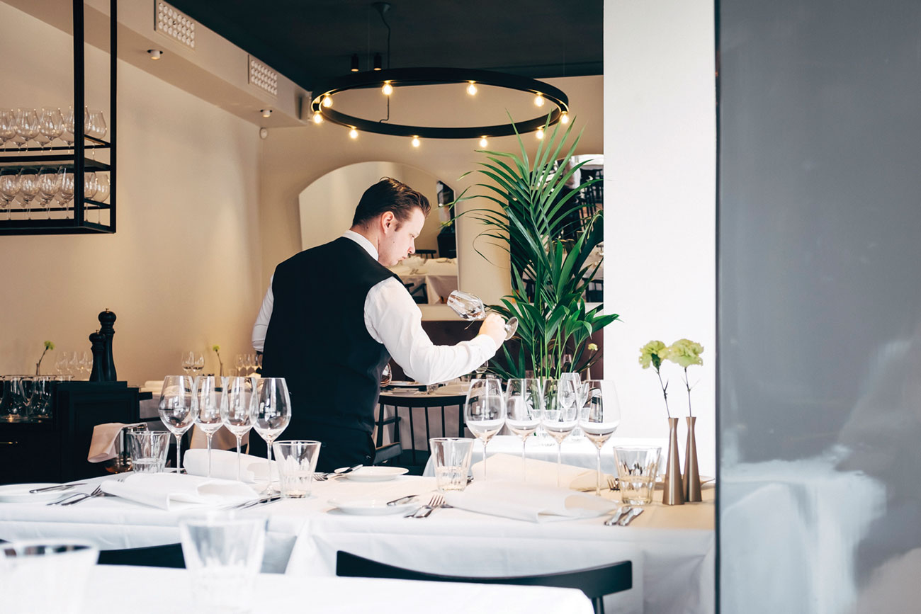 Vinkkeli, a waiter polishing glasses