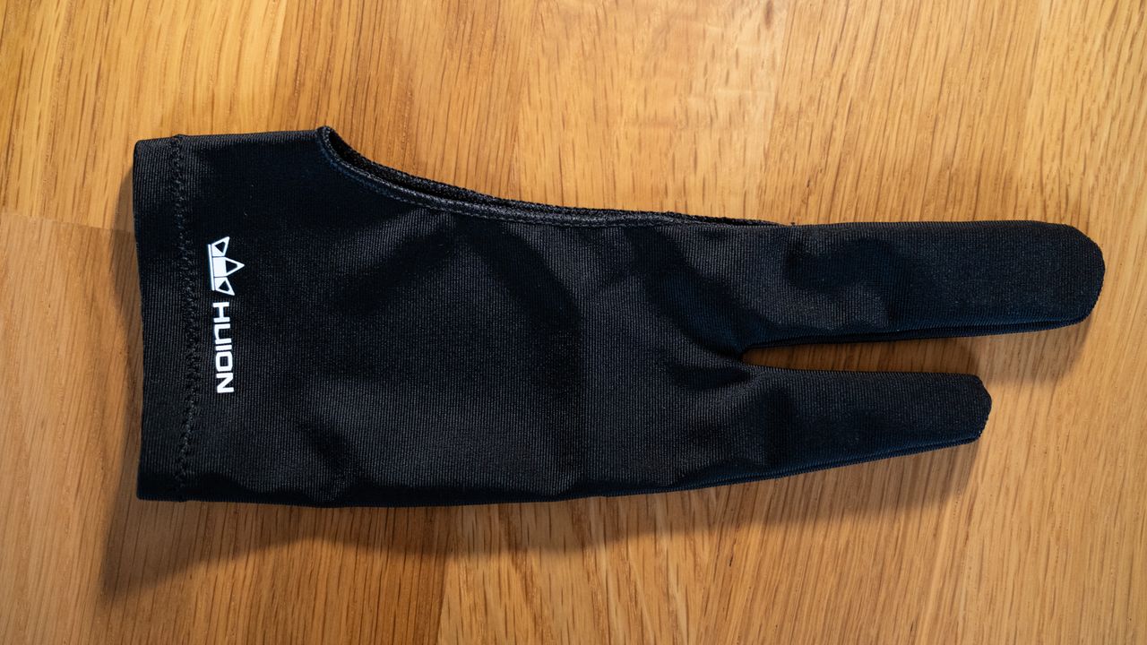 Glove accessory for a Huion Kamvas Pro 24 (4K) drawing tablet on a wooden surface