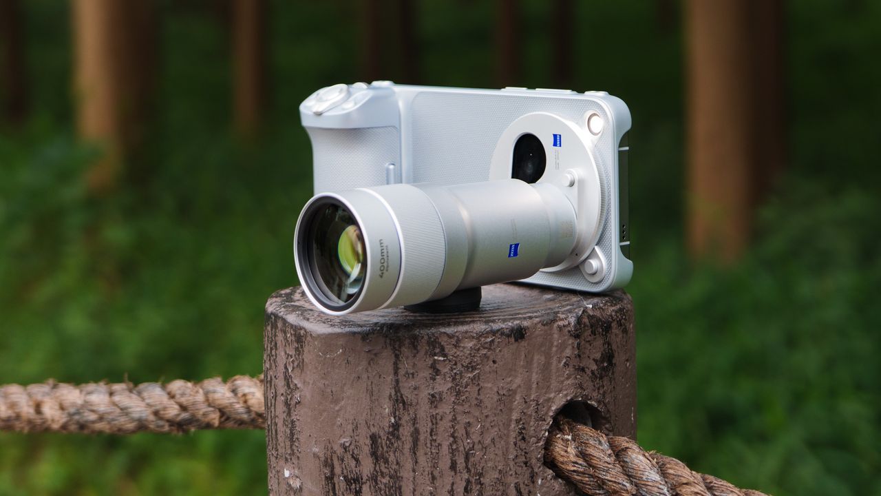 The Vivo X500 Pro Max phone with teleconverter lens attached, on a wooden post besides walkway in a birdlife reserve in Shanghai, China