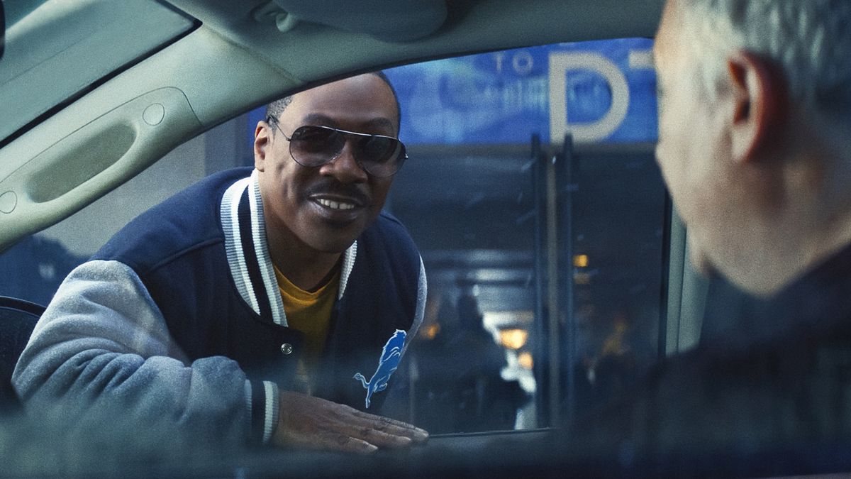 Axel Foley smiles and leans into someone&#039;s car window in Beverly Hills Cop: Axel F