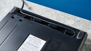 The compartment to store the extra linking cable on the underside of a Kinesis Freestyle Pro