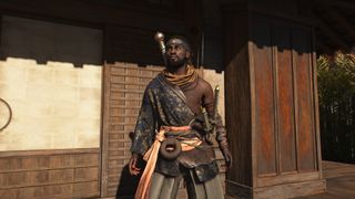 Assassin's Creed Shadows screenshot of Yasuke standing in front of the door to a building within a castle complex