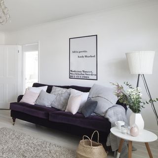 room with white wall and purple velvet sofa