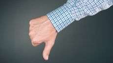 A man gives a thumbs-down, only his hand showing.