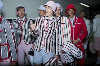 Group of male models wearing brightly coloured striped jackets & cheering