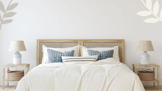 A bed with blue pillows and a patterned headboard
