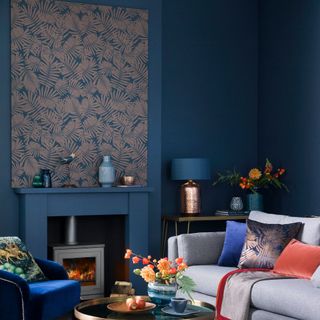 Blue painted living room with wallpapered panel above the fireplace