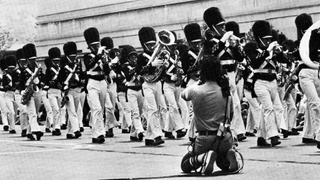 A contract cameraman covers the July 3 parade in Washington, D.C., from the sidelines. The parade marked the first time the author saw one of the (then)-new &lsquo;minicams&rsquo; in use.
