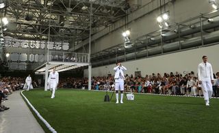 Models dressed in a contemporary take on cricket clothing marched across an AstroTurf field - with lines of cricket balls outlining its edges