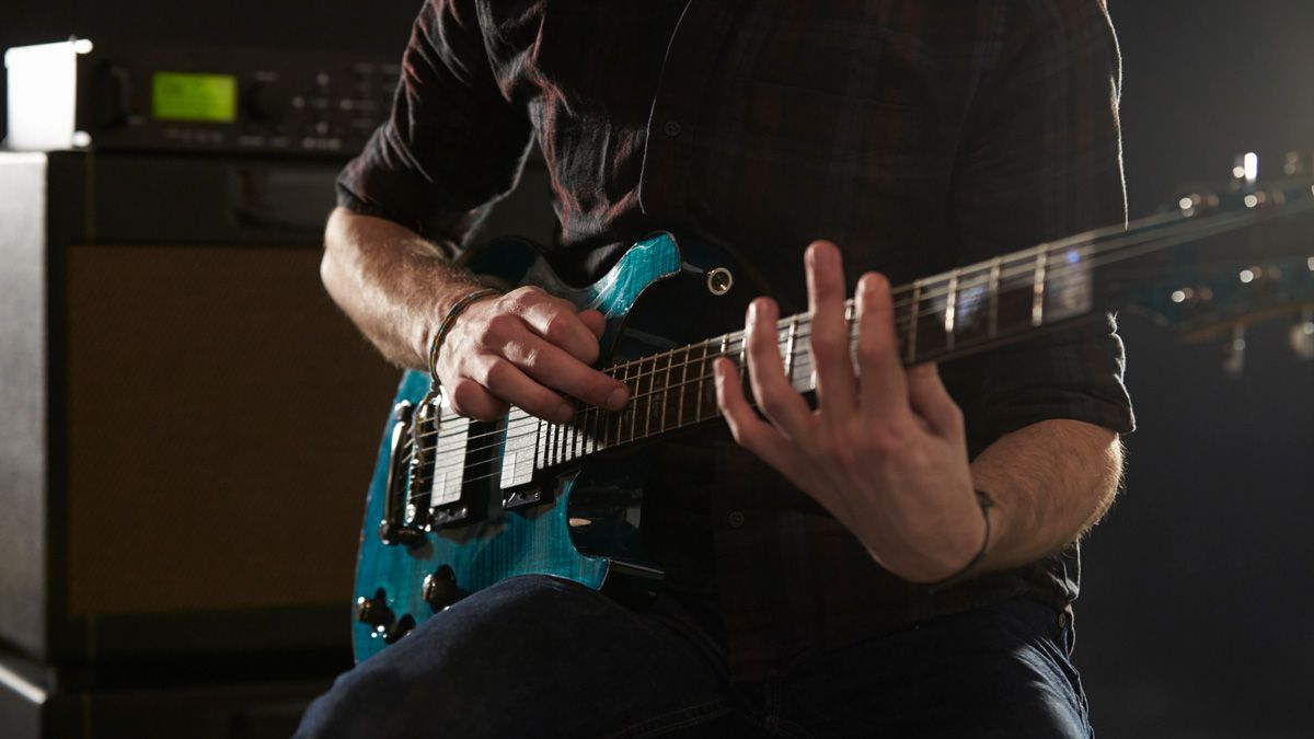 Close Up Of Man Using Tapping Technique On Electric Guitar