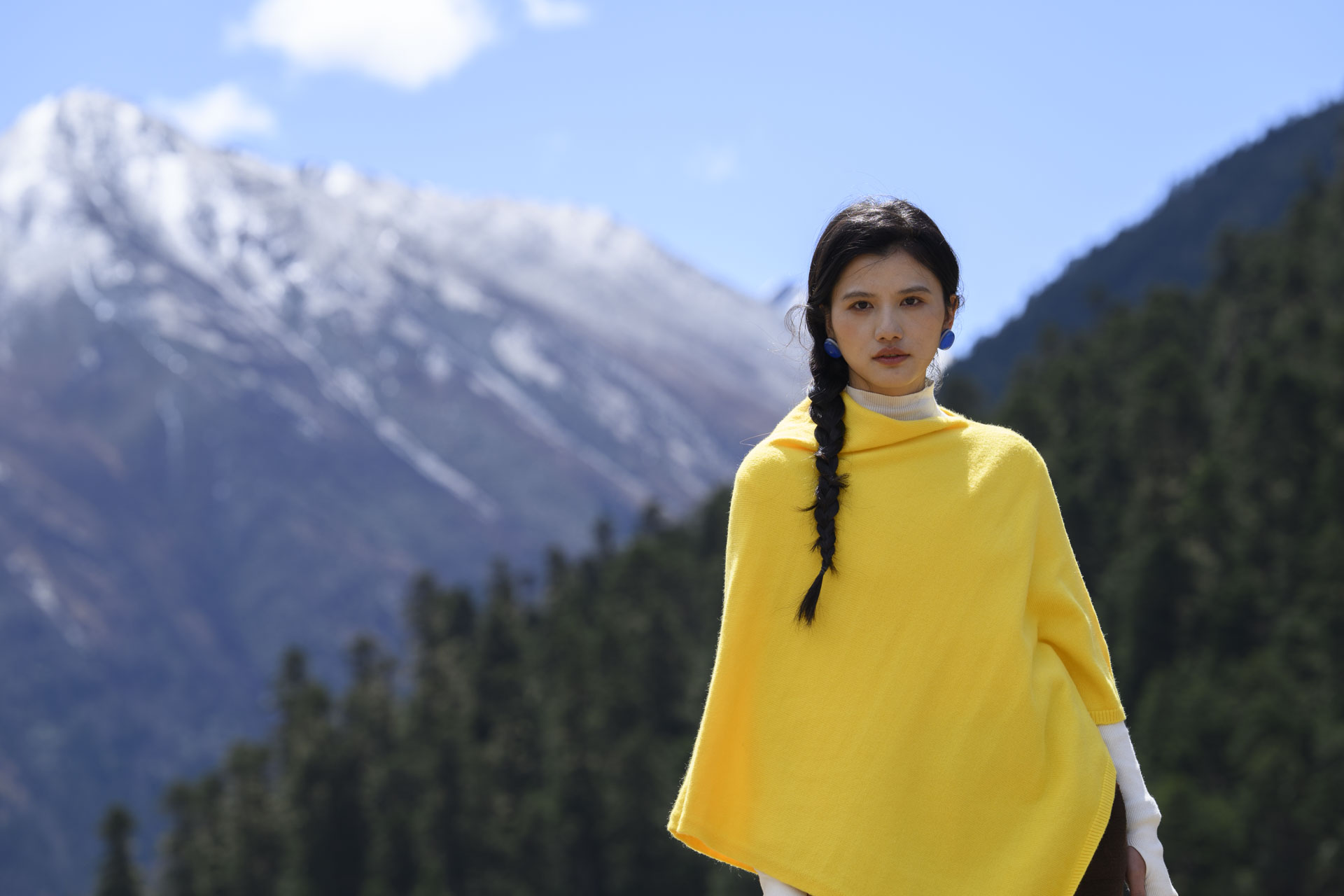 Nikon Z 70-200mm f/2.8 VR S II image gallery: female model in a yellow shawl in front of snow-covered mountains