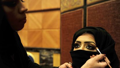 Saudi woman applies makeup on a model
