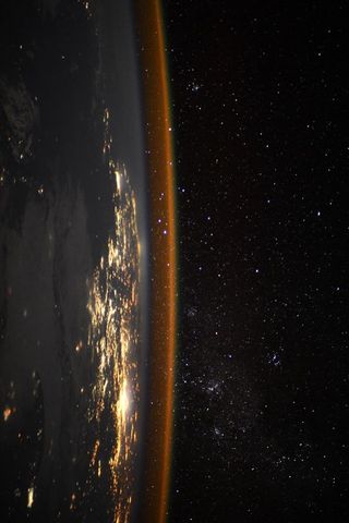 The sideways Earth glimmers in this photo taken from the International Space Station