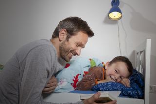 father reading bedtime story to son